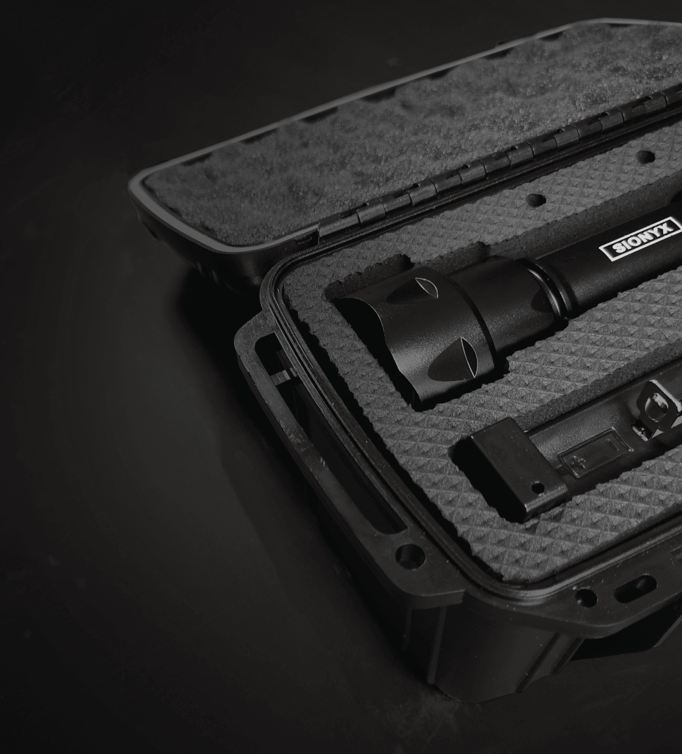 Close-up of open SiOnyx kit case with flashlight and accessories arranged in foam insert