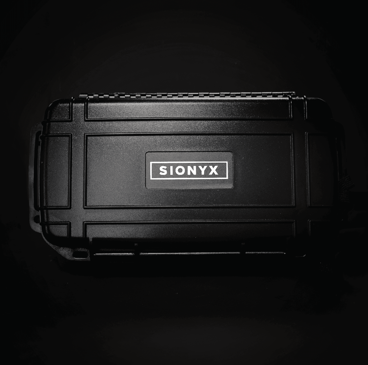 Closed SiOnyx Illuminator Kit case on a dark background with branding visible on lid