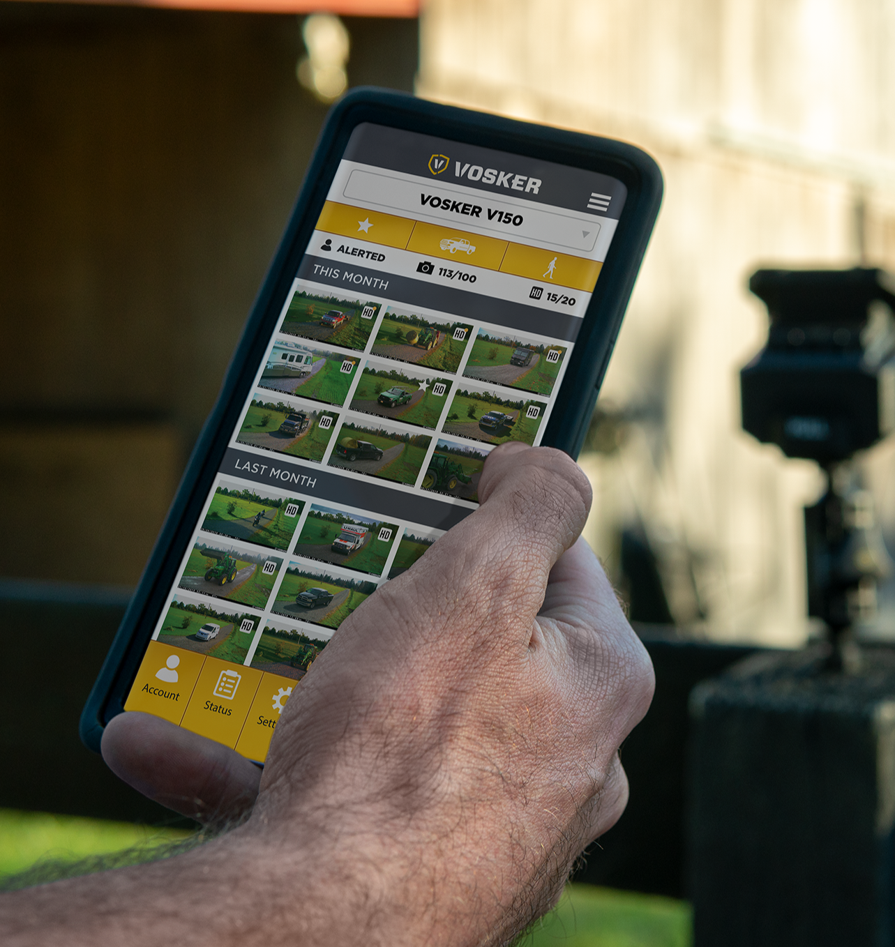 Close-up of user holding smartphone showing the Vosker app gallery of surveillance footage captured by the V150